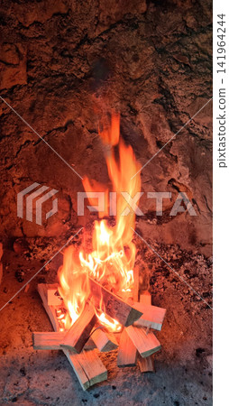 Wood fire burning in a stone fireplace Wood fire burning in a stone fireplace 141964244
