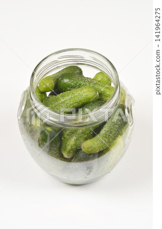 Open glass jar filled with green gherkin cucumbers Open glass jar filled with green gherkin cucumbers 141964275