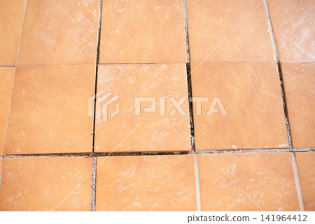 Damaged terracotta floor tiles with empty wide gaps renovation required top view Damaged terracotta floor tiles with empty wide gaps renovation required top view 141964412