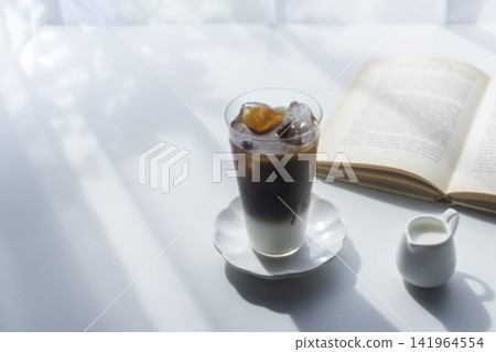 在夏日陽光下享受閱讀,再來一杯雙層冰咖啡歐蕾 在夏日陽光下享受閱讀,再來一杯雙層冰咖啡歐蕾 141964554