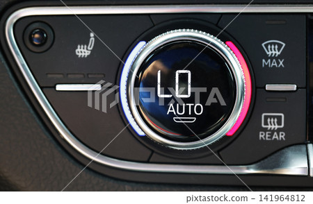 Automobile climate control panel close up view showing rotary dial digital display indicating temperature setting lowest level automatic mode selection functional buttons interior detail modern Automobile climate control panel close up view showing rotary dial digital display indicating temperature setting lowest level automatic mode selection functional buttons interior detail modern 141964812