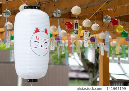 Lanterns with fox faces and summer wind chimes displayed on the grounds of Takekoma Shrine. Lanterns with fox faces and summer wind chimes displayed on the grounds of Takekoma Shrine. 141965199