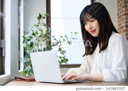Young businesswoman using laptop in office 141965387