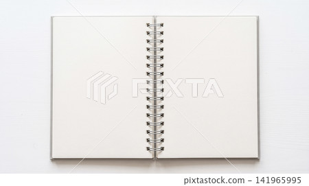 Open blank spiral wirebound sketchbook resting flat upon white wooden desktop background ready for creative writing drawing or daily educational school assignments Open blank spiral wirebound sketchbook resting flat upon white wooden desktop background ready for creative writing drawing or daily educational school assignments 141965995