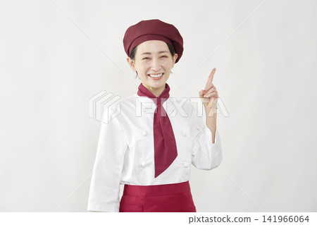 A female pastry chef points to the right. A female pastry chef points to the right. 141966064