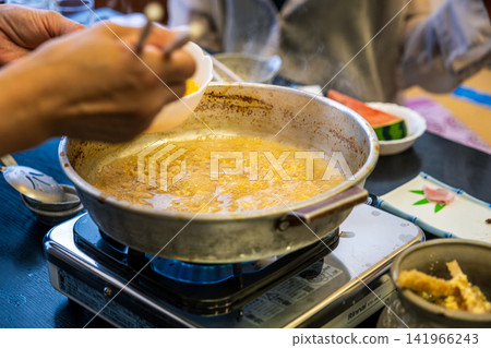 [#美食] 一道日式料理，以熱氣騰騰的雞蛋粥盛在鍋裡。 141966243