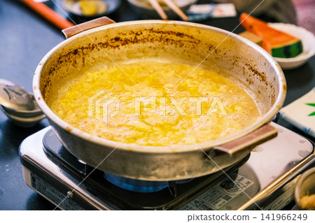 [#Food] A Japanese meal featuring piping hot egg porridge served in a pot. 141966249