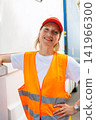 Portrait young adult happy smiling woman heavy truck driver modern cargo vehicle cabin background. Female person girl professional job career working driving freight engine lorry. Logistics industry 141966300