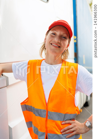 Portrait young adult happy smiling woman heavy truck driver modern cargo vehicle cabin background. Female person girl professional job career working driving freight engine lorry. Logistics industry Portrait young adult happy smiling woman heavy truck driver modern cargo vehicle cabin background. Female person girl professional job career working driving freight engine lorry. Logistics industry 141966300