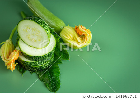 Fresh garden zucchini composition with blossoms on light green background Fresh garden zucchini composition with blossoms on light green background 141966711