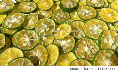 Close-up background photo with slices of shikwasa fruit laid out. Close-up background photo with slices of shikwasa fruit laid out. 141967147