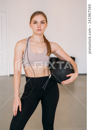 Female sport model. Pilates training. Calm bodybuilder standing with professional gym equipment in studio. Body strength physical therapy. Female sport model. Pilates training. Calm bodybuilder standing with professional gym equipment in studio. Body strength physical therapy. 141967560