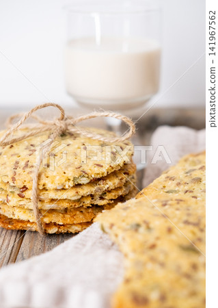 Healthy food. Grain pastry. Round crackers stack tied with jute placed on counter. Tasty cookies flax pumpkin seeds with yogurt glass. Healthy food. Grain pastry. Round crackers stack tied with jute placed on counter. Tasty cookies flax pumpkin seeds with yogurt glass. 141967562
