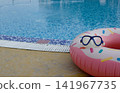 Inflatable swim ring and diving mask by swimming pool 141967735
