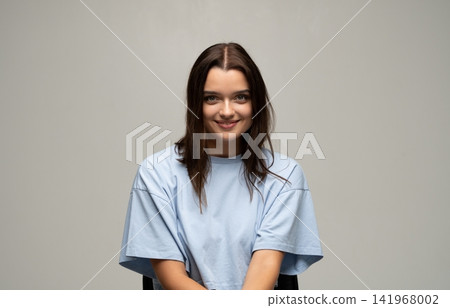 Young brunette woman smiling, expressing happiness and positive emotion in a relaxed studio portrait Young brunette woman smiling, expressing happiness and positive emotion in a relaxed studio portrait 141968002
