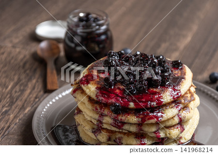 A breakfast scene featuring homemade blueberry sauce and freshly baked pancakes. A breakfast scene featuring homemade blueberry sauce and freshly baked pancakes. 141968214
