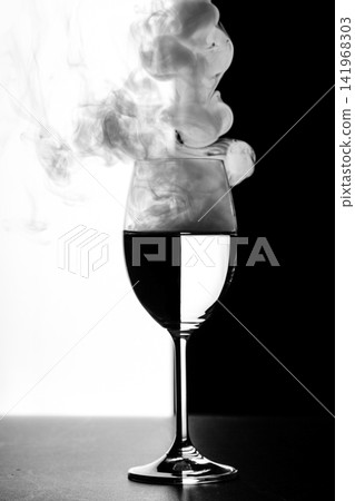 a glass of water and smoke on a black and white background a glass of water and smoke on a black and white background 141968303