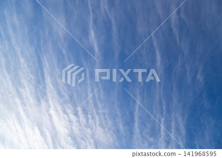 Wispy Cirrus Clouds Streaking Across a Bright Blue Sky Wispy Cirrus Clouds Streaking Across a Bright Blue Sky 141968595