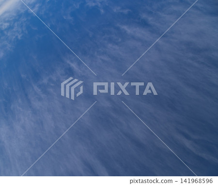 Wispy Cirrus Clouds Streaking Across a Deep Blue Sky Wispy Cirrus Clouds Streaking Across a Deep Blue Sky 141968596