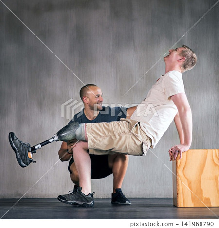 Trainer, person with a disability and prosthetic leg and training in physiotherapy, studio and gym block. Male people, physiotherapist and amputee for wellness, fitness and exercise in rehab center Trainer, person with a disability and prosthetic leg and training in physiotherapy, studio and gym block. Male people, physiotherapist and amputee for wellness, fitness and exercise in rehab center 141968790
