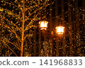 Streetlights at night and a golden illuminated tree 141968833