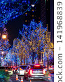 The city streets at night, illuminated with lights, and the trails of car lights. 141968839