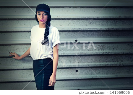 Garage, portrait and girl in city with fashion, cap or gender neutral clothes for upcycling, street style or inspiration. Streetwear, face or gen z woman in New York for y2k, sale or thrifting choice Garage, portrait and girl in city with fashion, cap or gender neutral clothes for upcycling, street style or inspiration. Streetwear, face or gen z woman in New York for y2k, sale or thrifting choice 141969006
