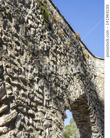 Close up view of ancient aqueduct stonework showing texture and arch in a historical location under clear sky 141969288
