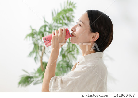 女人正在喝罐裝果汁;能量飲料 女人正在喝罐裝果汁;能量飲料 141969468