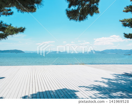 陽光明媚的夏日,從香川縣直島的白色木製平台上眺望瀨戶內海。 陽光明媚的夏日,從香川縣直島的白色木製平台上眺望瀨戶內海。 141969528