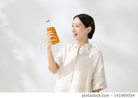 A woman holding a plastic bottle of beverage A woman holding a plastic bottle of beverage 141969584