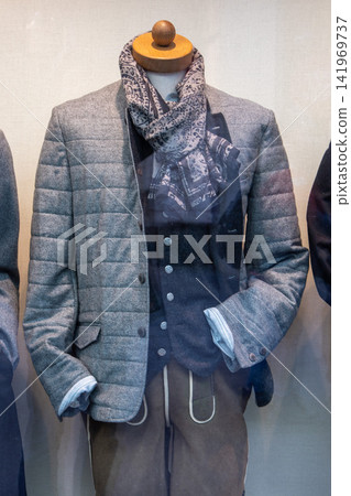 Menswear mannequin in quilted blazer and patterned scarf shop window Menswear mannequin in quilted blazer and patterned scarf shop window 141969737