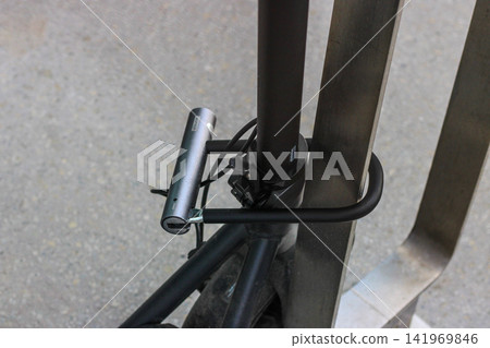 Bicycle secured with lock to metal bike rack Bicycle secured with lock to metal bike rack 141969846