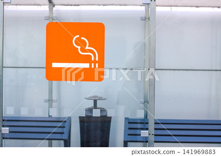 Modern glass smoking shelter with designated smoking area sign Modern glass smoking shelter with designated smoking area sign 141969883