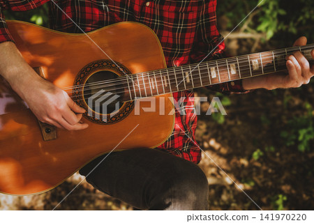 Closeup Of Musician Hands Strumming Acoustic Guitar Closeup Of Musician Hands Strumming Acoustic Guitar 141970220