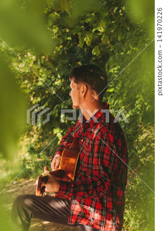 Side View of Man Playing Acoustic Guitar Side View of Man Playing Acoustic Guitar 141970226