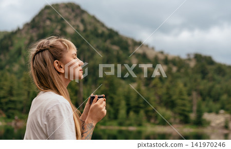 Woman with Eyes Closed Holding Mug Outdoors Woman with Eyes Closed Holding Mug Outdoors 141970246