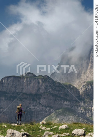 Woman Backpacker Standing on Alpine Mountain Meadow Woman Backpacker Standing on Alpine Mountain Meadow 141970268