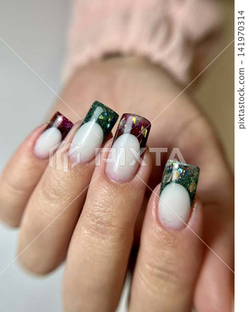 Woman's hand with red and green french manicure, nail design, christmas Woman's hand with red and green french manicure, nail design, christmas 141970314
