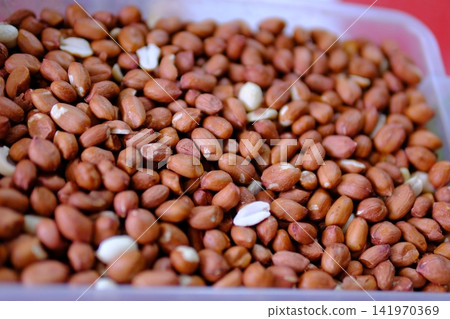 Raw peanuts in shell and kernels arranged in close up as natural ingredient for snacks baking cooking and everyday plant based nutrition with simple rustic presentation Raw peanuts in shell and kernels arranged in close up as natural ingredient for snacks baking cooking and everyday plant based nutrition with simple rustic presentation 141970369