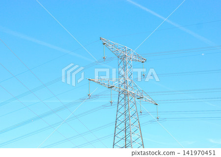 High voltage electrical pylon and power lines over rural field High voltage electrical pylon and power lines over rural field 141970451