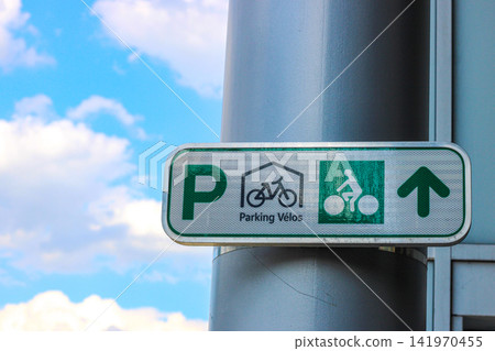 Bicycle parking directional sign against blue sky Bicycle parking directional sign against blue sky 141970455
