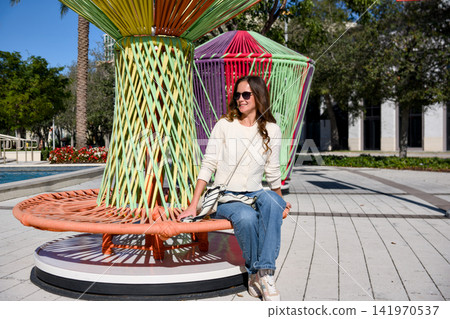 Woman Relaxing On Colorful Woven Bench Woman Relaxing On Colorful Woven Bench 141970537