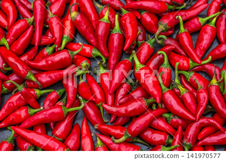 Overhead View of Fresh Red Chili Peppers on Dark Surface 141970577