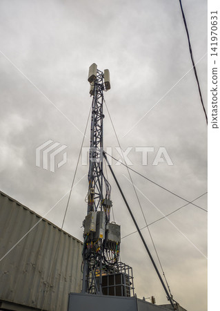 Telecommunications Tower with Antennas Against Cloudy Sky 141970631