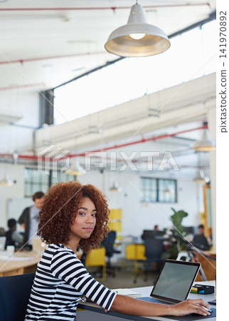 African woman, portrait and laptop for web design in office for project, email and content creation. Proud female person, graphic developer and start up company, desk and computer in modern workplace African woman, portrait and laptop for web design in office for project, email and content creation. Proud female person, graphic developer and start up company, desk and computer in modern workplace 141970892
