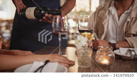 Restaurant, waiter and couple pour wine for date, anniversary celebration and romantic dinner. Hospitality, fine dining and server with people for alcohol tasting for relationship, love and bonding Restaurant, waiter and couple pour wine for date, anniversary celebration and romantic dinner. Hospitality, fine dining and server with people for alcohol tasting for relationship, love and bonding 141970920