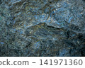 Textured rock serpentine surface with blue and green mineral patterns Close up 141971360