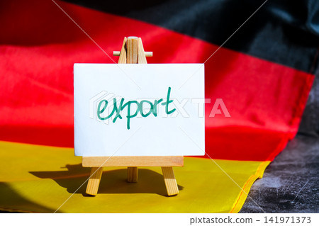 Paper note with words EXPORT on National symbol of Germany. German wave silky flag background. Concept of economy industry global market international shipping 141971373