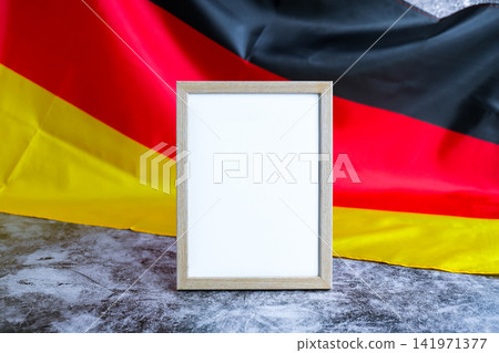 Empty white paper frame National symbol of Germany. Mock up advertisement template German wave Germany fabric flag background. Copy space for your text. Independence Empty white paper frame National symbol of Germany. Mock up advertisement template German wave Germany fabric flag background. Copy space for your text. Independence 141971377